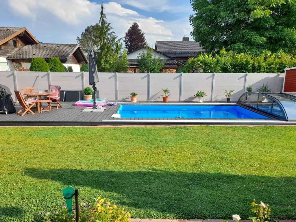 a swimming pool in a yard next to a fence at Ferienwohnung an der Singold 