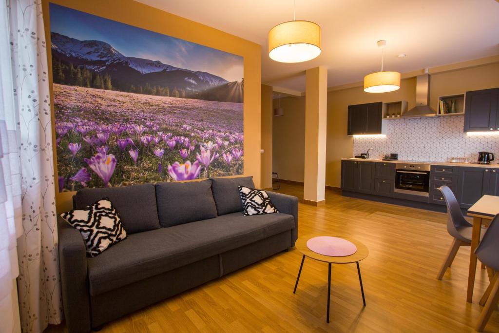 a living room with a couch and a painting of flowers at Koślówka in Biały Dunajec