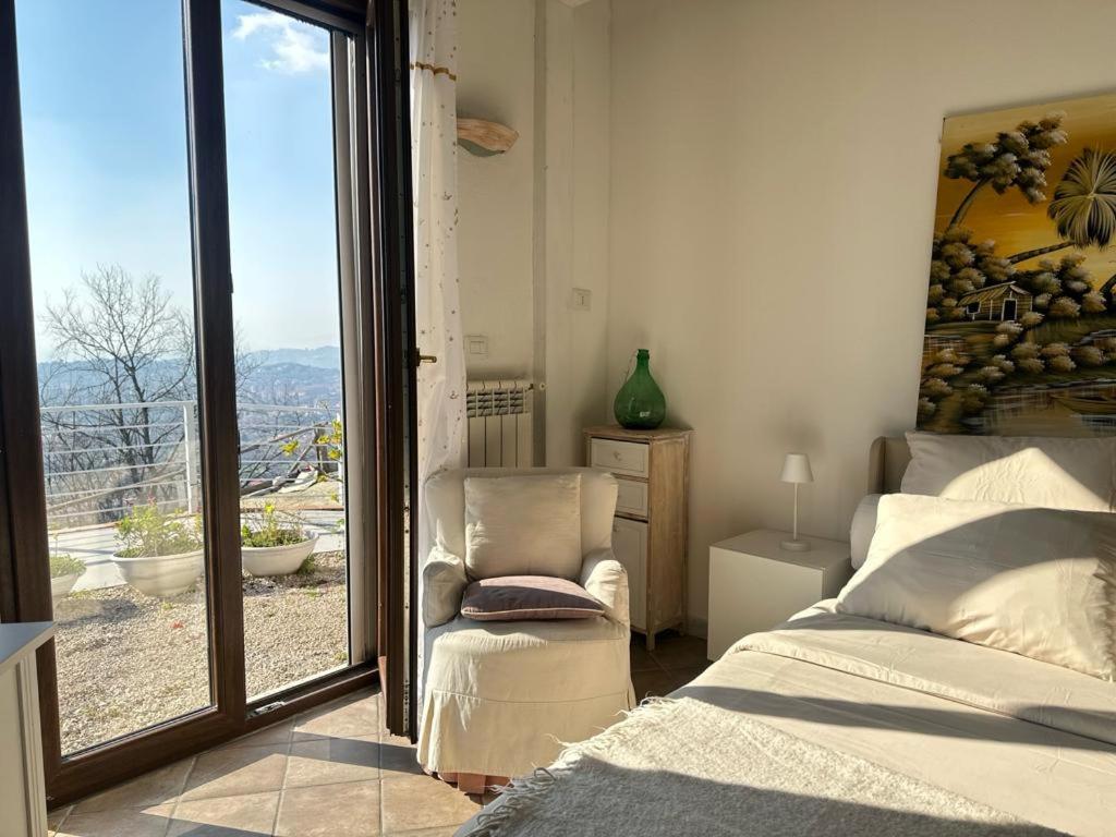 a bedroom with a bed and a chair and a window at La Perla di Max in Naples