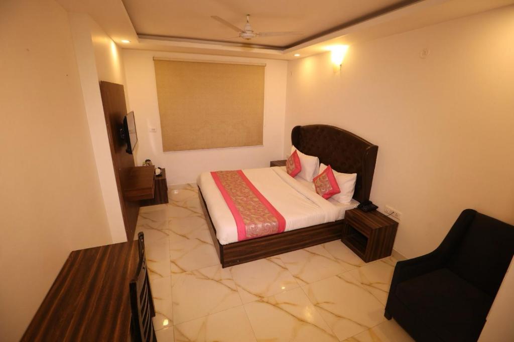 um pequeno quarto com uma cama num quarto em Hotel Kelvish Plaza-Near IGI Airport Terminal-3 em Nova Deli