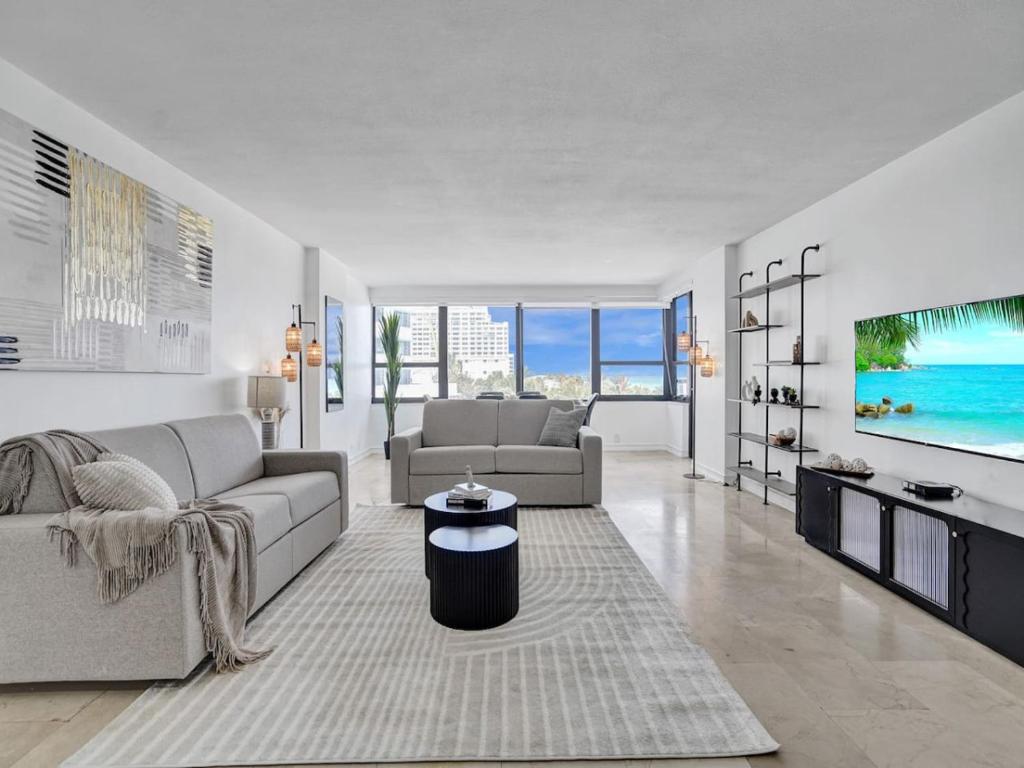 uma sala de estar com um sofá e uma televisão em Oceanfront Beach Retreat Beach Service 502 em Miami Beach