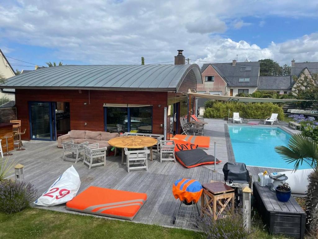 um pátio com uma mesa e cadeiras e uma piscina em Villa de 3 chambres avec piscine privee terrasse et wifi a Landunvez em Landunvez