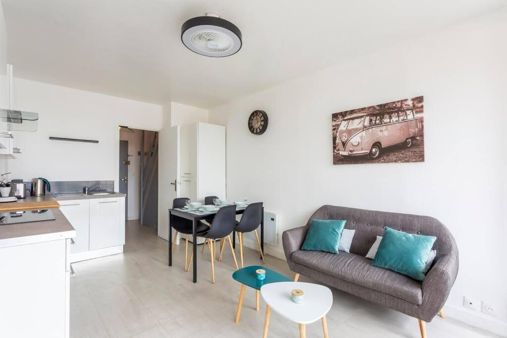 Il dispose d'une cuisine et d'un salon avec un canapé et une table. dans l'établissement Chez Marlène - Superbe appartement duplex à proximité des plages, au Grau-du-Roi