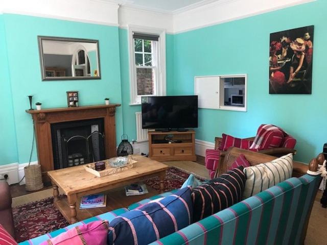 een woonkamer met een bank en een tv bij Silverdale Apartments in Eastbourne