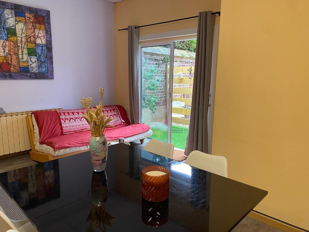 un salon avec un canapé et une table en verre dans l'établissement Appartement lumineux rez-de-chaussée prox GARE, à Cambrai