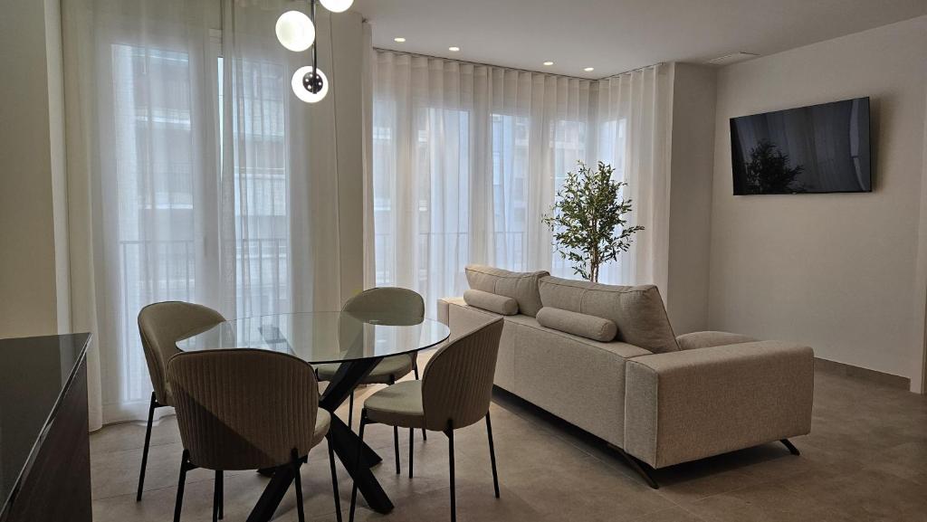 uma sala de estar com um sofá, uma mesa e cadeiras em Imperial Apartamentos Valencia em Valência