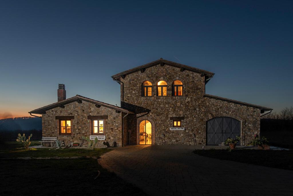 ein großes Steinhaus mit eingeschaltetem Licht in der Unterkunft Il casale del Mignone in Blera