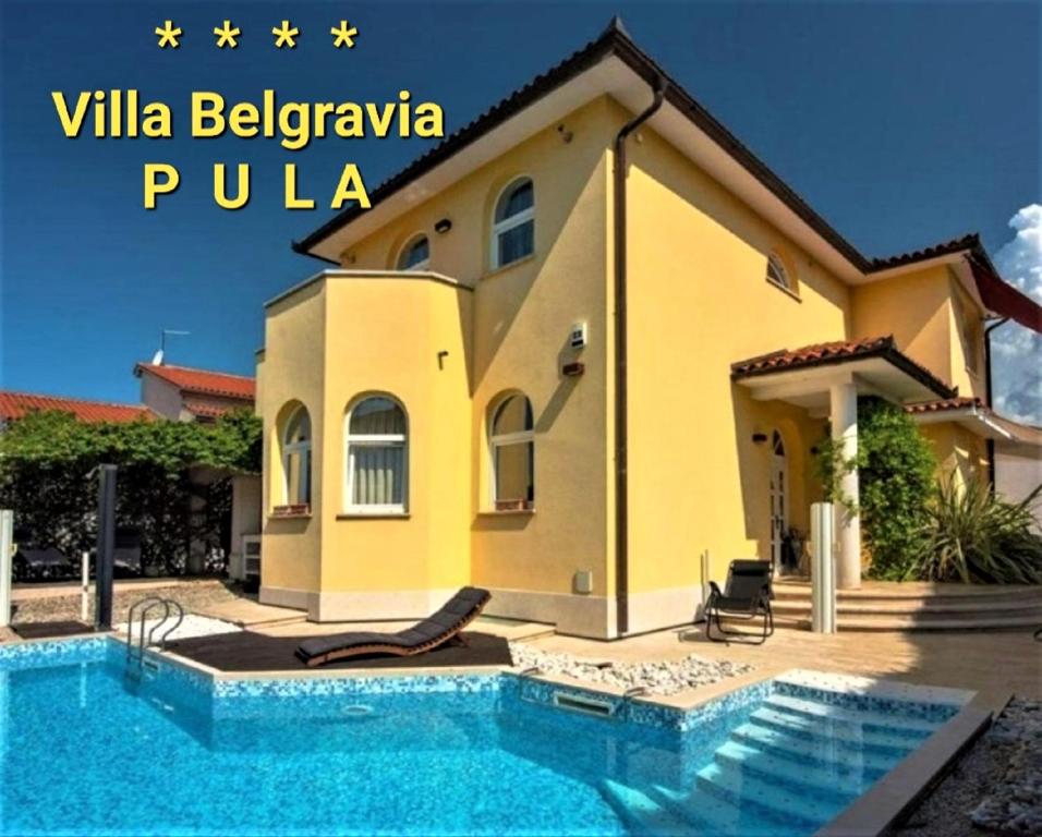 eine Villa mit einem Pool vor einem Haus in der Unterkunft Villa Belgravia in Pula