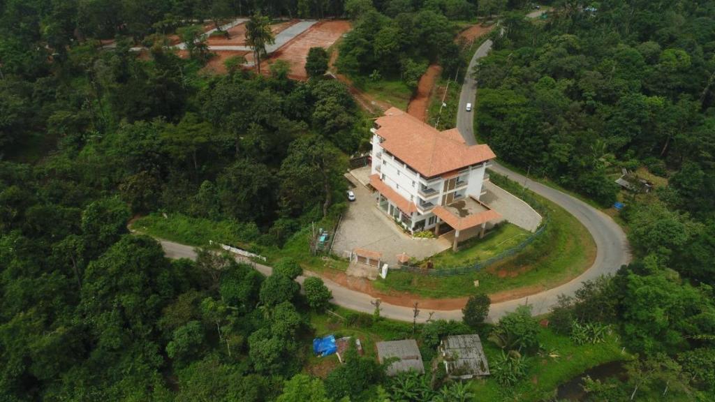 uma vista aérea de uma casa grande numa estrada em Doves Danta Resort, Coorg em Cherambane