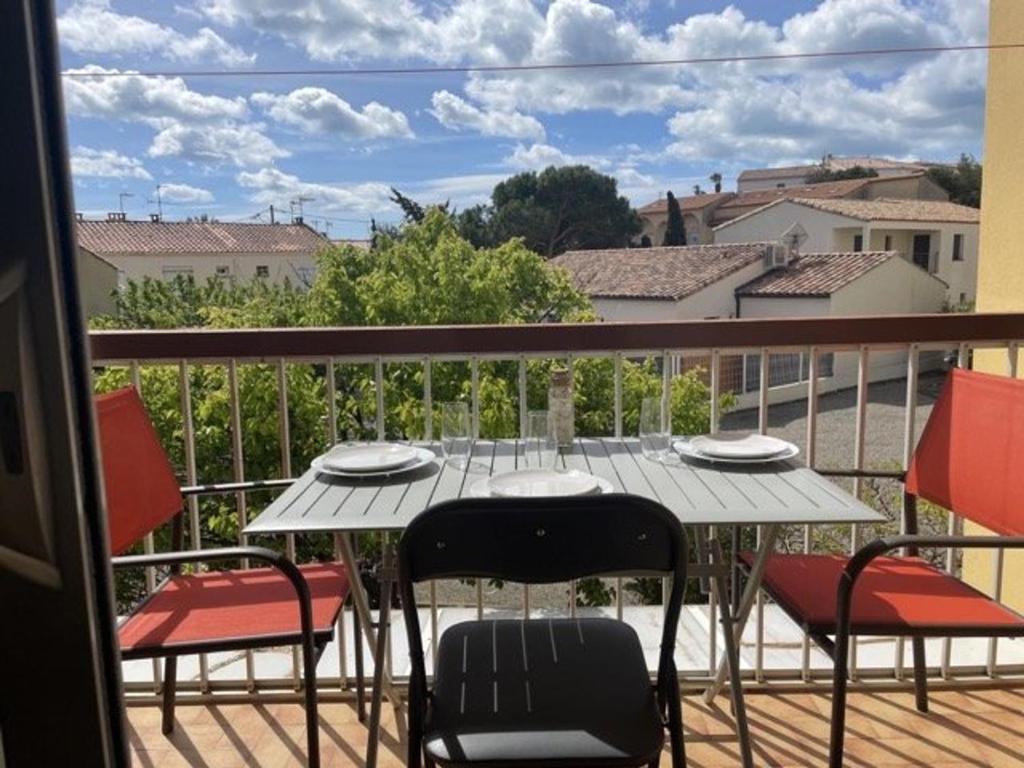 un balcon avec une table et des chaises sur une terrasse dans l'établissement Charmant T2 climatisé proche plage avec balcon - 4 couchages, Port de Saint Pierre La Mer - FR-1-229D-119, à Fleury