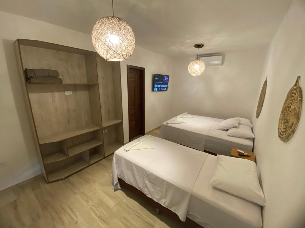 a small room with two beds and a couch at Pousada Terra das Águas Barreirinhas in Barreirinhas