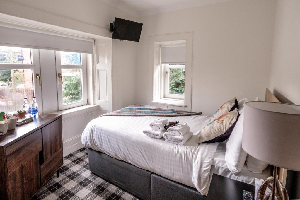 a bedroom with a bed and two windows at Cardross Inn 