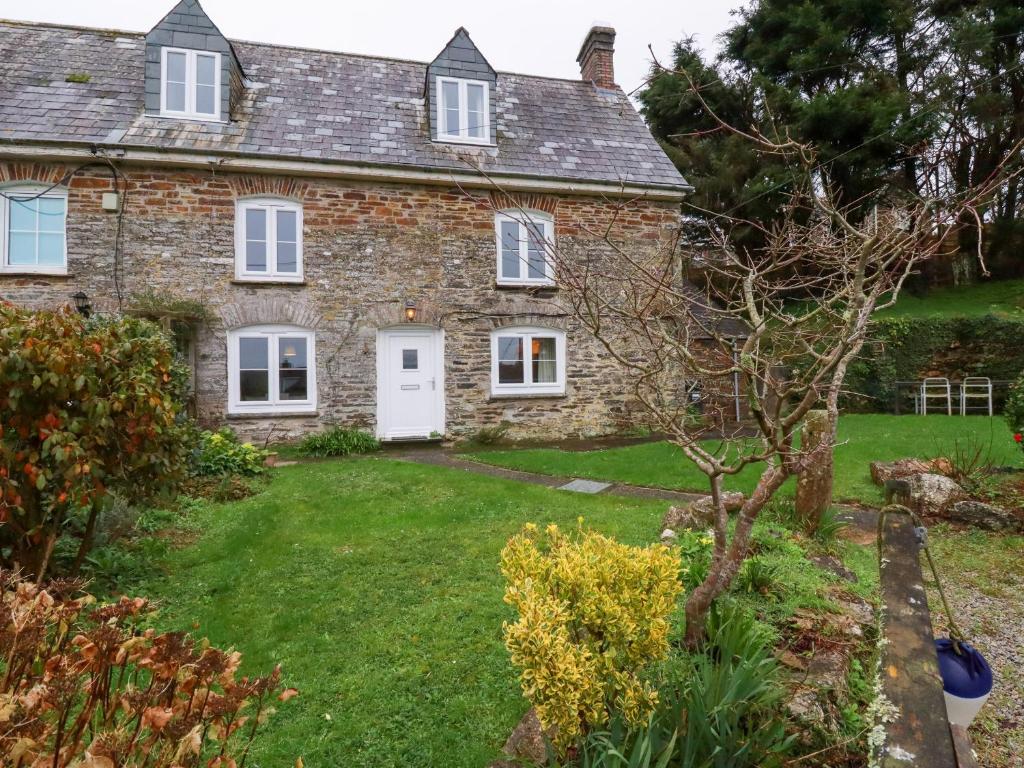 een oud stenen huis met een tuin bij Lanvean Farmhouse in Newquay