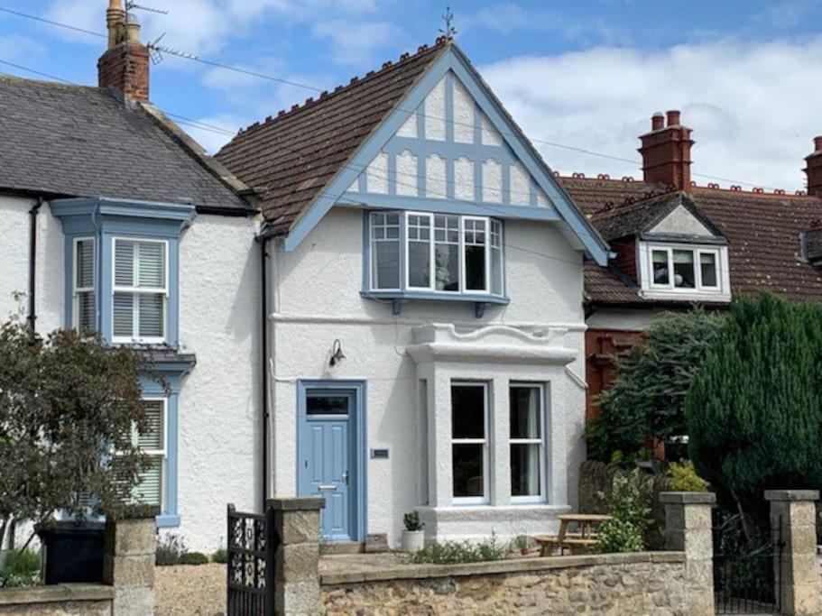 a white house with a blue door at The Blue Cottage with luxurious Super King bed in Darlington