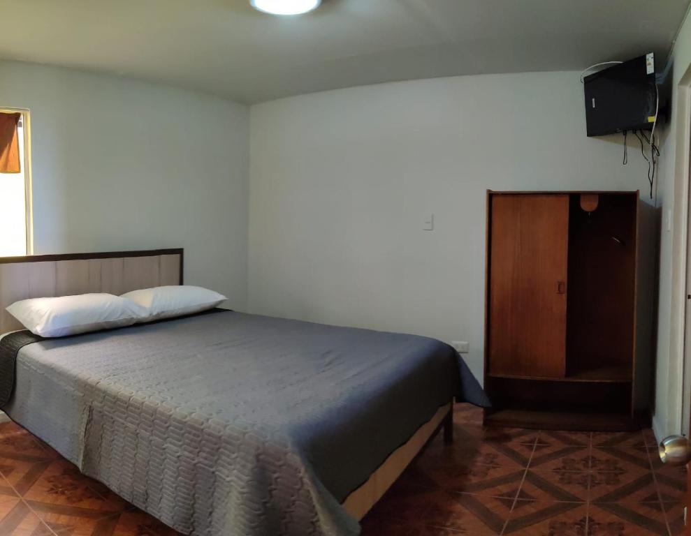 1 dormitorio con 1 cama y armario de madera en HOTEL MARISOL en Iquique