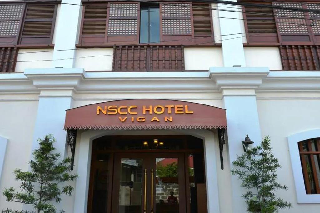 a hotel with a sign on the front of a building at NSCC Hotel Vigan in Vigan