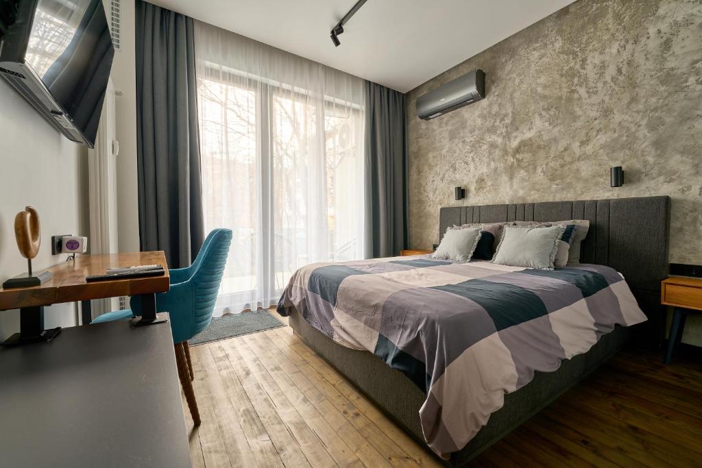 1 dormitorio con cama, escritorio y ventana en Luxury 2 Bedroom Apartment - Private Garden en Sofía