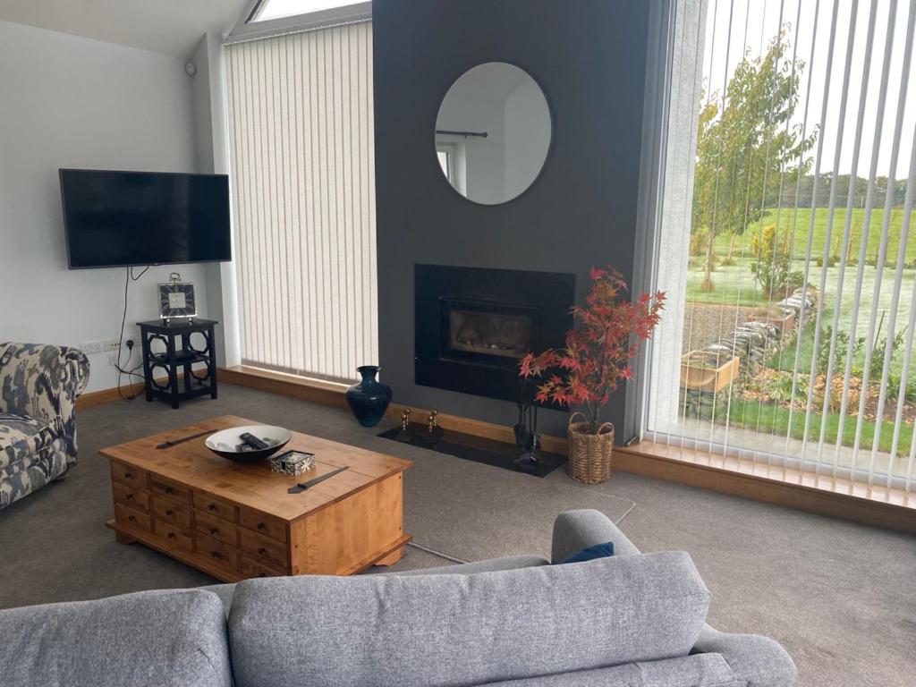 a living room with a couch and a coffee table at Highmains in Dumfries