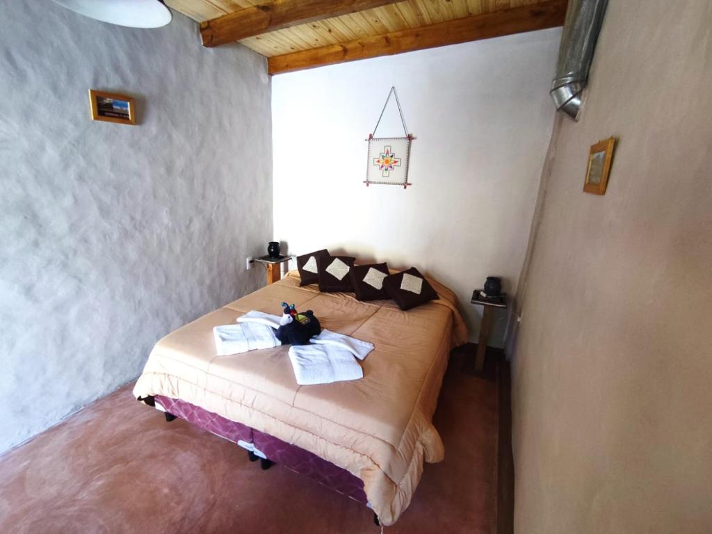 sypialnia z łóżkiem z ręcznikami w obiekcie Retama w mieście Tilcara