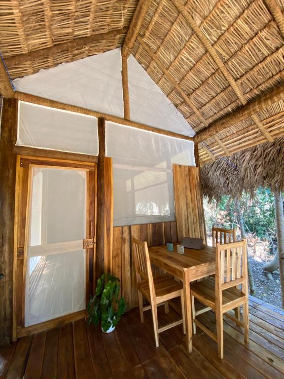 a dining room with a table and chairs and a window at EcoAraguaia Jungle Lodge in Caseara