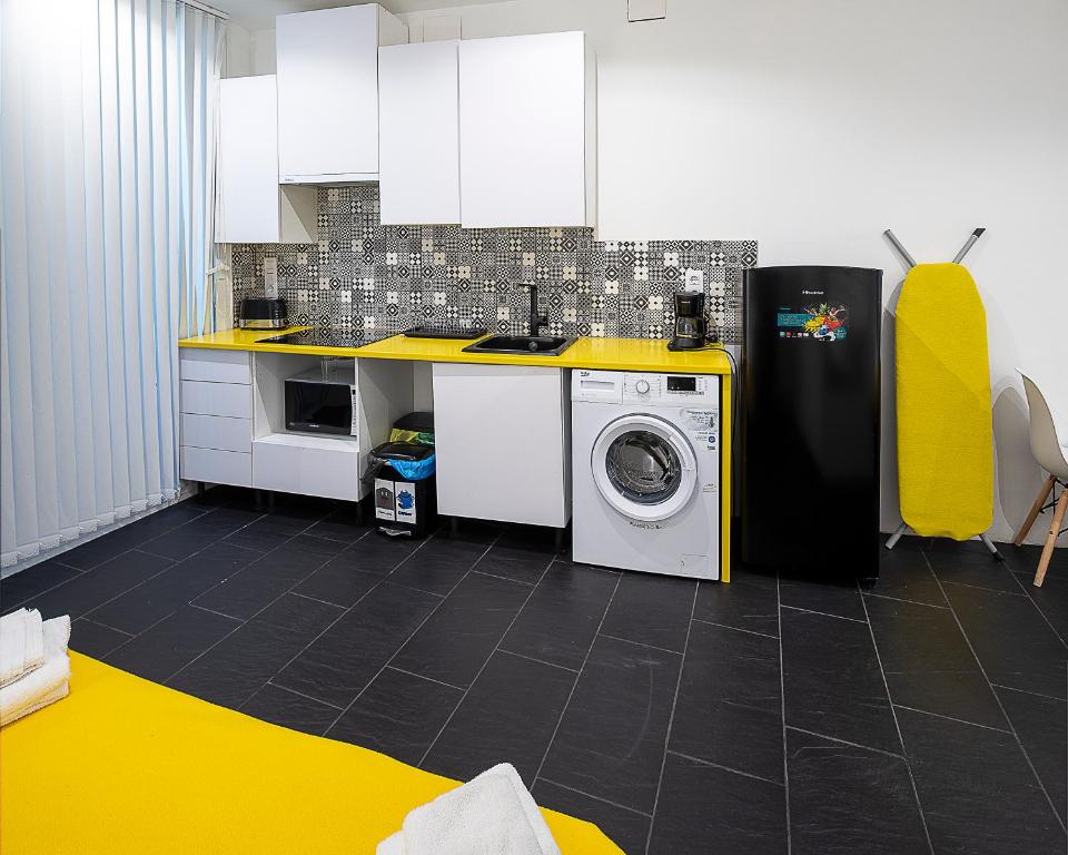 a kitchen with a washing machine and a yellow counter at El Estudio de La Artista - El casar de Leo in Alburquerque
