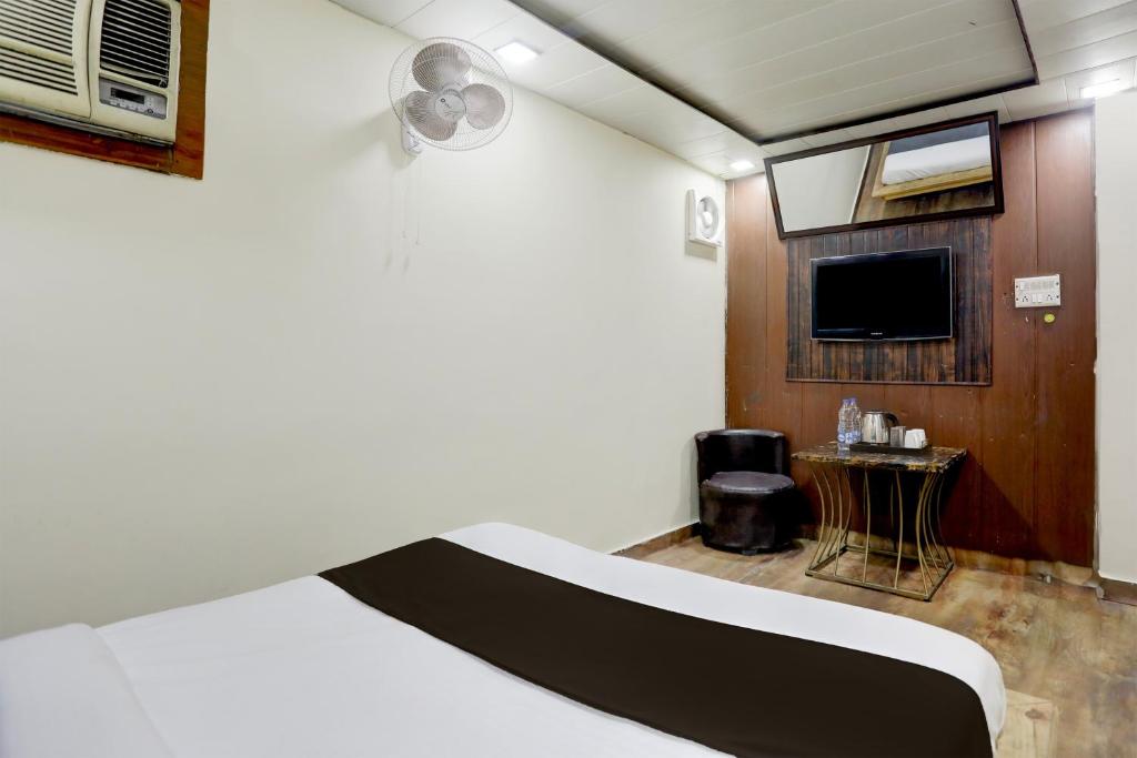 ein Hotelzimmer mit einem Bett und einem TV in der Unterkunft Hotel Kalila Near Max Hospital in Neu-Delhi