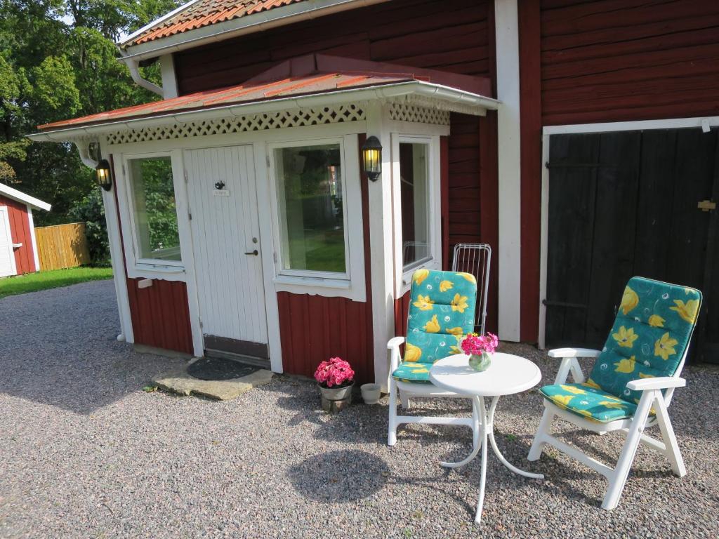 dos sillas y una mesa frente a un edificio en Huldas Gård en Kumla