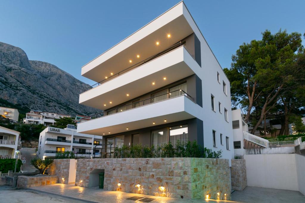a white building with lights on it at Apartmani Pino 1 in Baška Voda