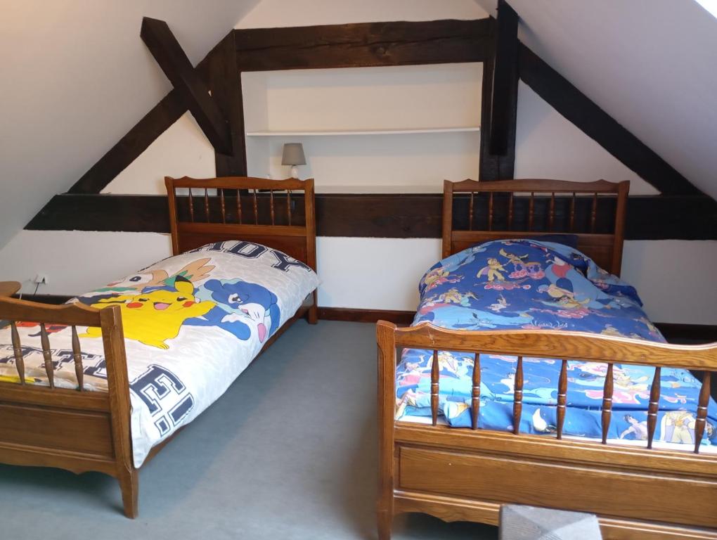 two twin beds in a room with a attic at L'orée des 3 Rivières in Is-sur-Tille