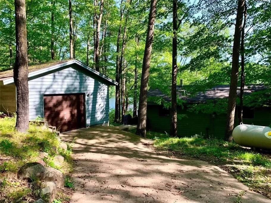 un pequeño cobertizo en medio de un bosque en Cabin on the lake, and trails!, en Birchwood