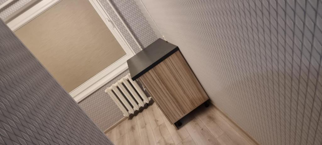 a room with a radiator and a chair on a wooden floor at Cute Flat in Kėdainiai