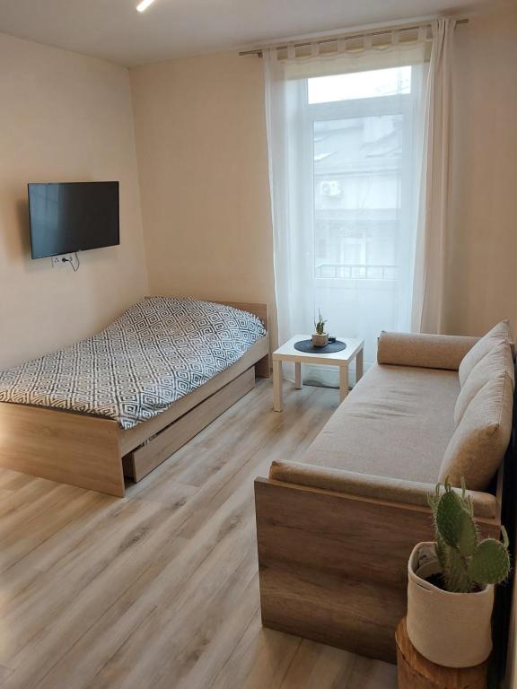 a bedroom with two beds and a tv on the wall at Studio near Old Town in Krakow