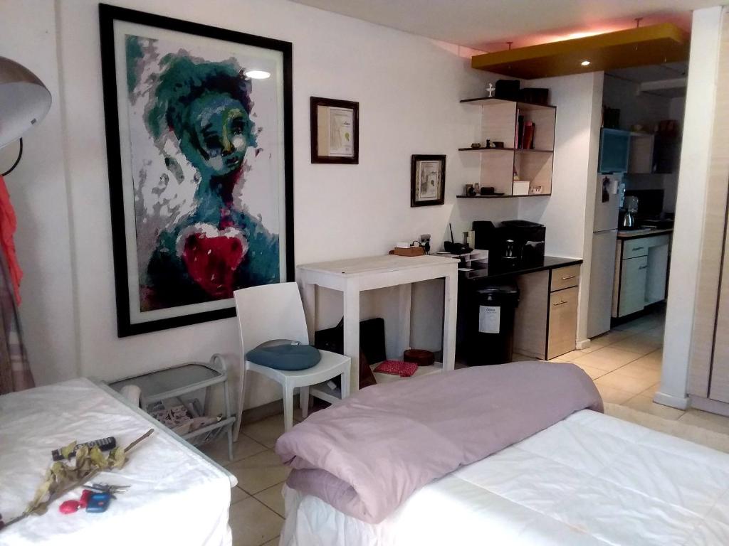 a bedroom with two beds and a painting on the wall at Charming apartment in Pretoria