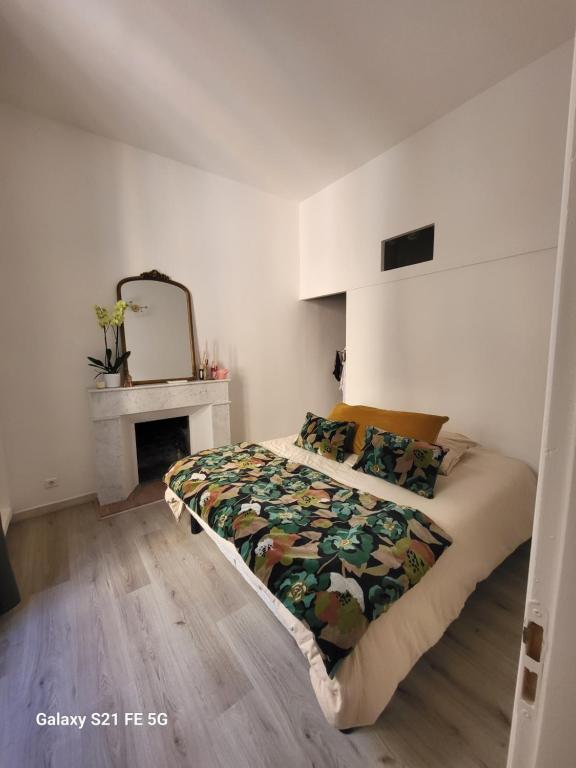 - une chambre avec un lit, une cheminée et un miroir dans l'établissement Cosy & Charm Ajaccio centre, à Ajaccio
