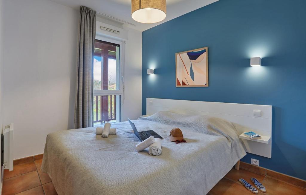 Un dormitorio azul con una cama con dos animales de peluche. en Résidence Odalys Domaine Iratzia, en San Juan de Luz