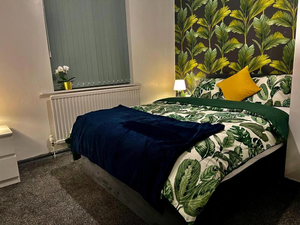 a bedroom with a bed with a blue comforter at Charming 2-Bedroom Home with Modern Amenities in Oldham