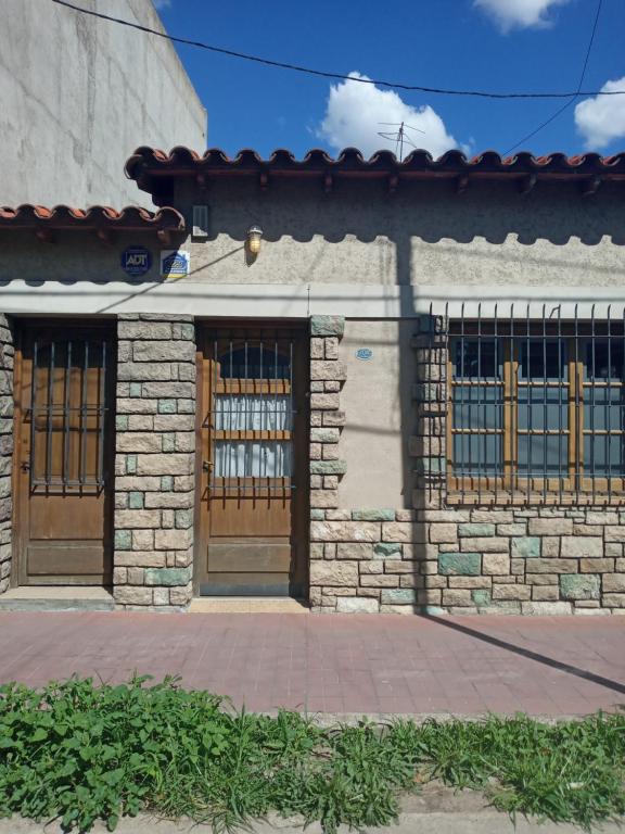 a building with two wooden doors and a brick wall at La posada del Colibrí in Mendoza