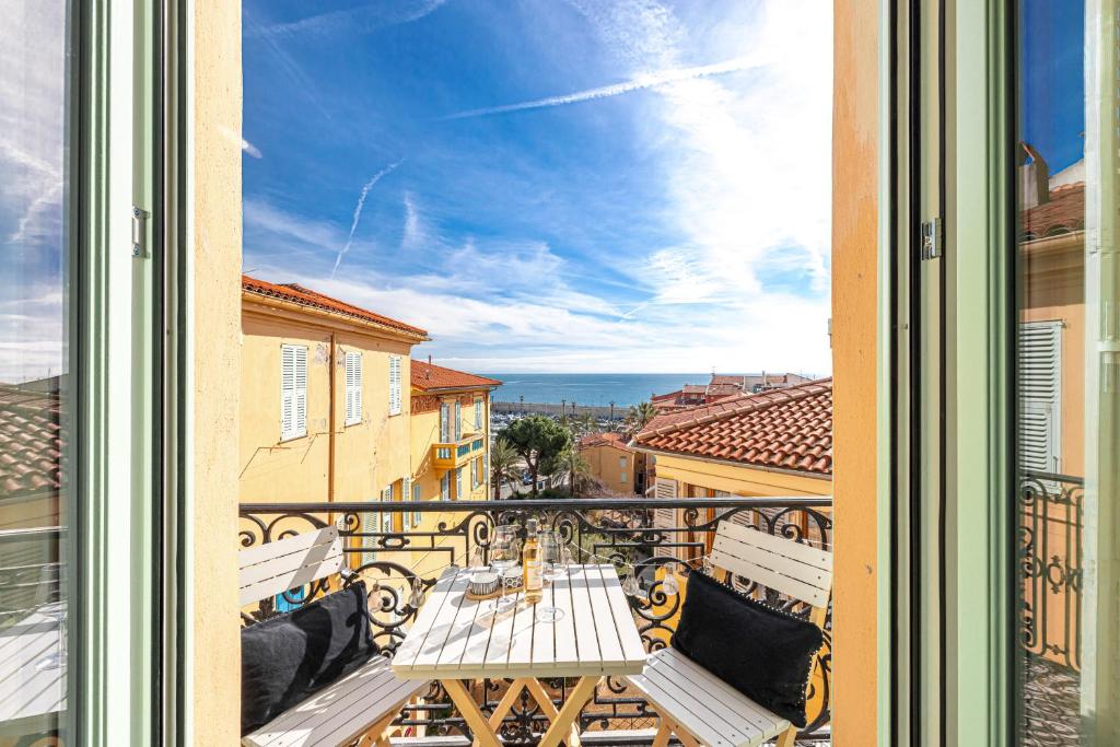 un balcon avec une table et une vue sur l'océan dans l'établissement Le Bréa, Élégant appartement, jolie vue mer, à Menton