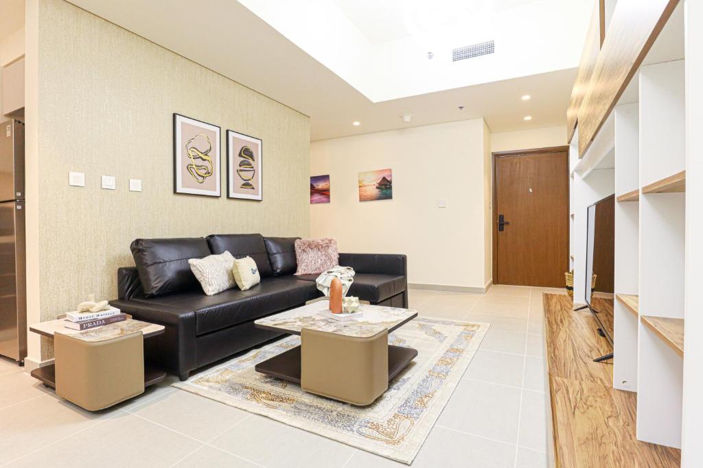 uma sala de estar com um sofá preto e uma mesa em HiGuests - Tranquil Luxury 1BR Apt in the Heart of the City em Dubai