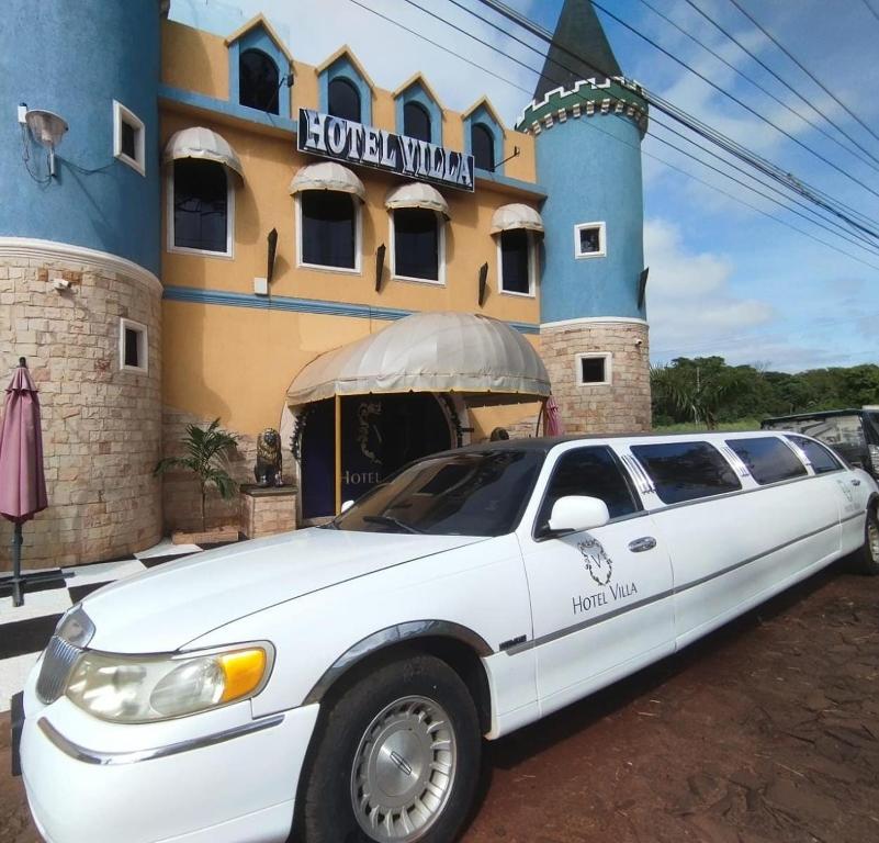 a white limousine parked in front of a building at Hotel Villa in San Juan del Paraná