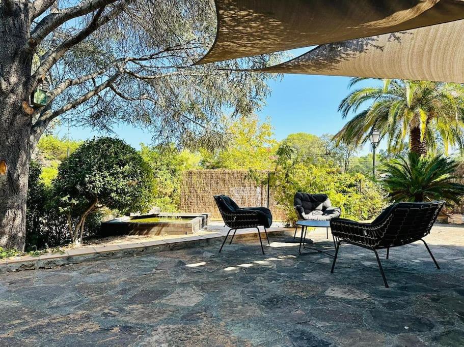 3 chaises et une table sur une terrasse dans l'établissement La Tranquille - rez de villa - jardin & plage, à Fréjus