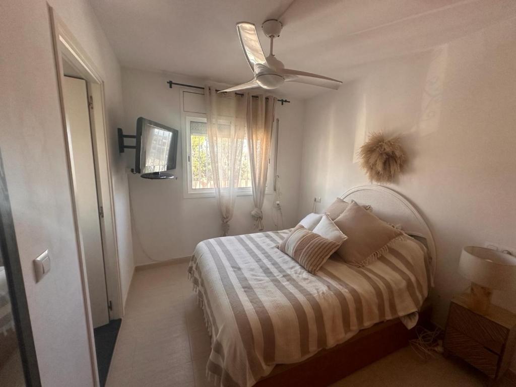 ein kleines Schlafzimmer mit einem Bett und einem Deckenventilator in der Unterkunft Casa Montseny - Con piscina - 6P in Empuriabrava