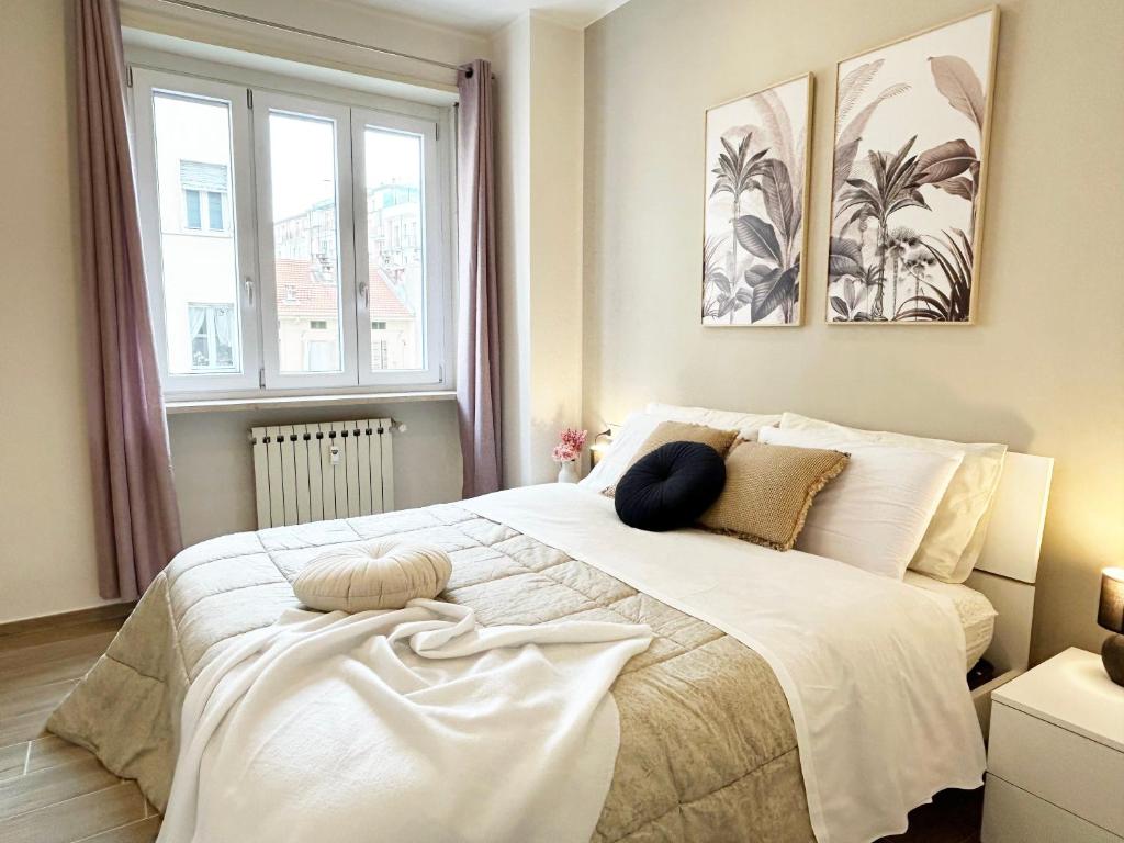 a bedroom with a large white bed with pillows on it at Quick Home - Orchidea in Biella