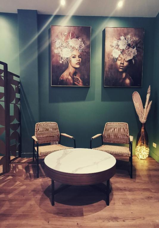une chambre avec deux chaises, une table et un tableau dans l'établissement La Discretion by Connexion, à Cannes