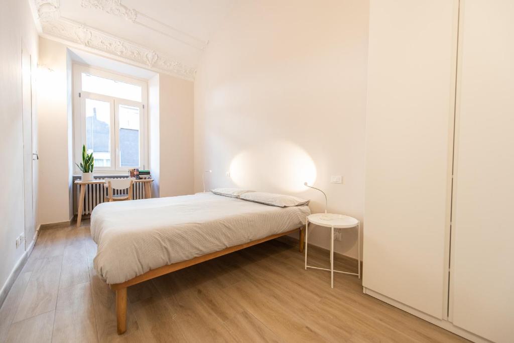 ein weißes Schlafzimmer mit einem Bett und einem Fenster in der Unterkunft Centro città - Comodo per visitare la città in Turin