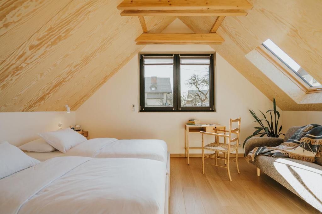 a attic bedroom with two beds and a desk at Plener Istebna in Istebna