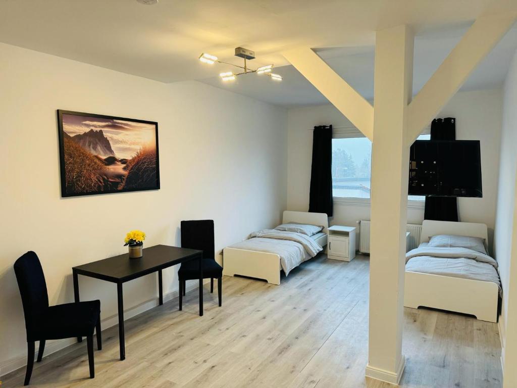 um quarto com duas camas e uma mesa em Private Zimmervermietung Felix em Trebbin