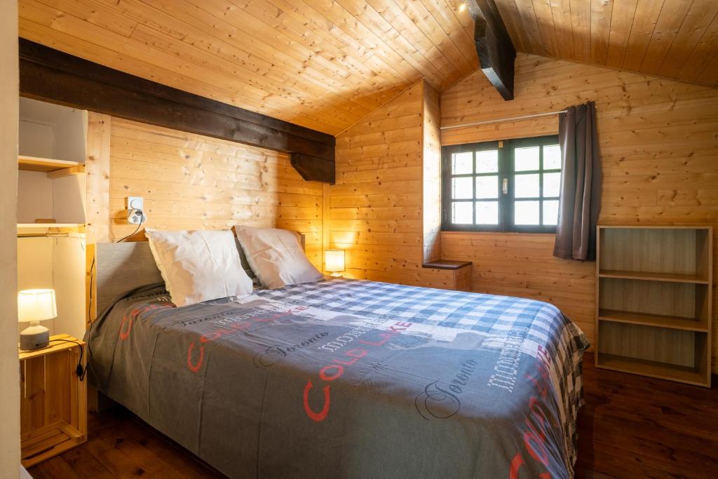 - une chambre avec un lit dans une cabane en bois dans l'établissement Grand Chalet St-Lary centre 13 à 15 pers, à Saint-Lary-Soulan