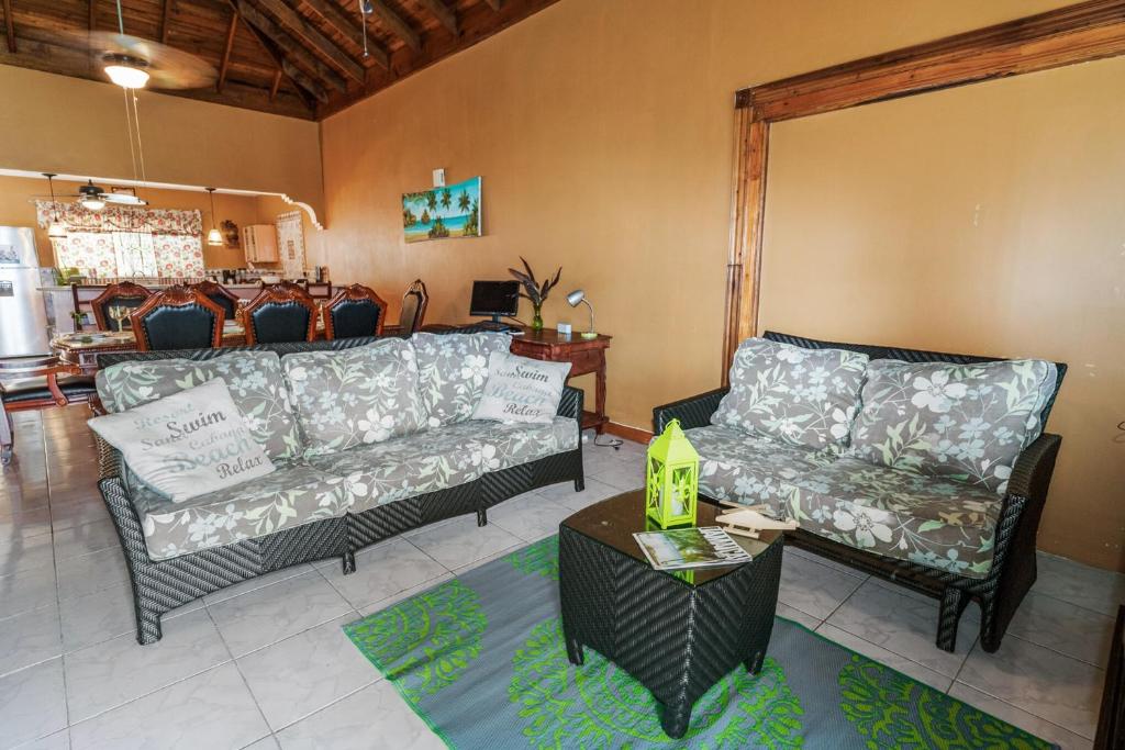 a living room with two couches and a table at YanceyLargo-6BR Two-Story Estate with Mountain Views in Montego Bay