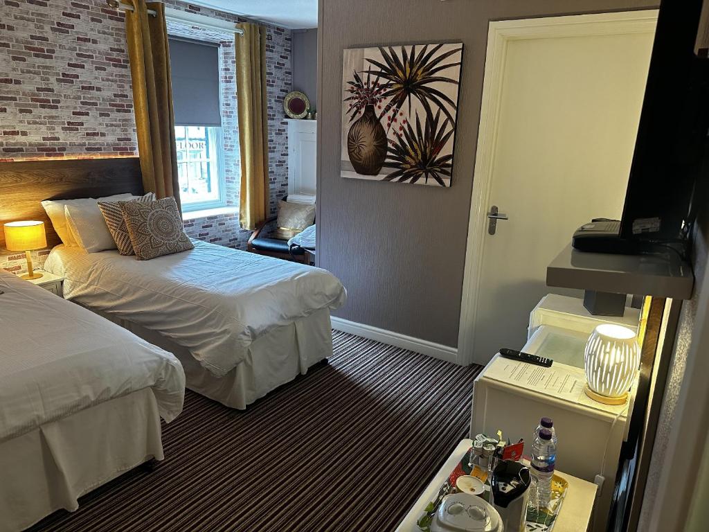 a hotel room with two beds and a television at The Cricketers Arms in Barnard Castle